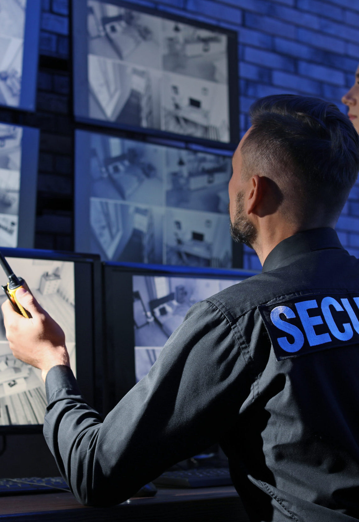 Security guards monitoring modern CCTV cameras indoors